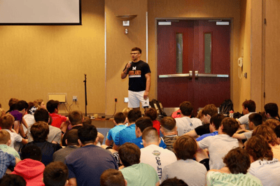 Assistant coach discussing wrestling techniques at camp.