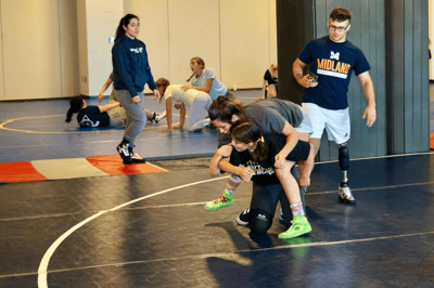 Two girls sparring at summer wrestling camp.