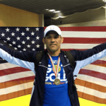 Coach Mike Schyck posing with an American flag. 