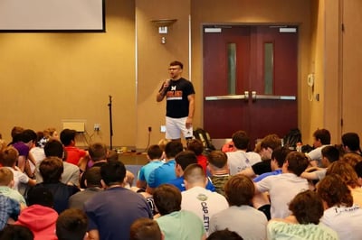 Assistant coach discussing wrestling techniques at camp.