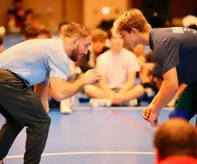Coach Zain Retherford sparring with a teen wrestler at summer camp.