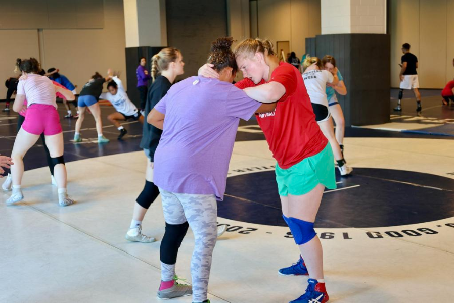 Women wrestlers grappling at summer camp.