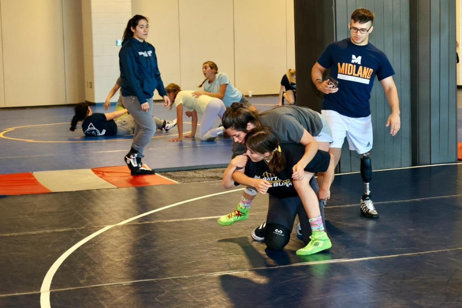 Two girls sparring at summer wrestling camp. 