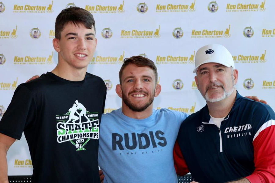 Zain Retherford posing with a camper and another assistant coach. 