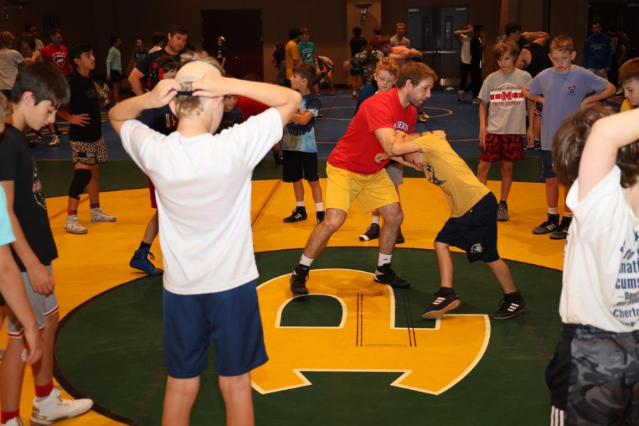 Youth wrestler wrestling with a coach.