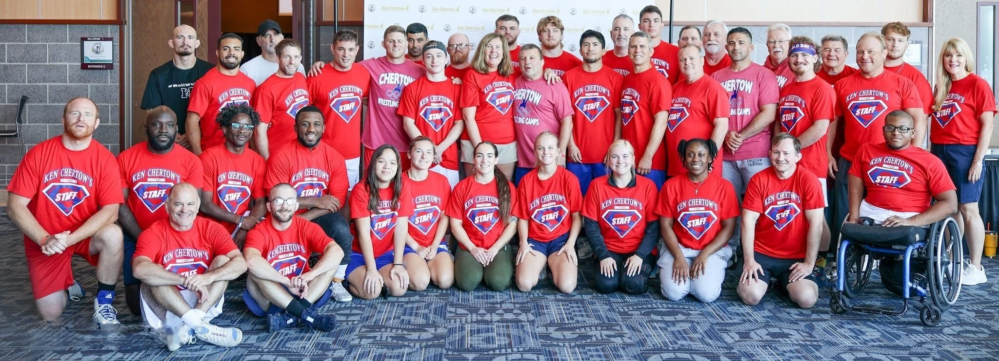 The 2025 Gold Medal Training Camp coaching staff lined up for a group photo at Ken Chertow's summer wrestling camp