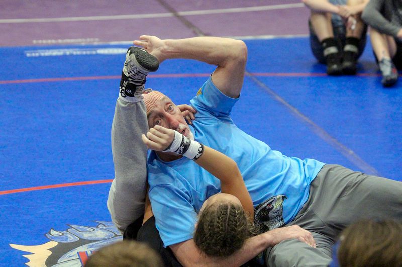 Wade Schalles demonstrating a move from his back while campers watch at Ken Chertow wrestling camp