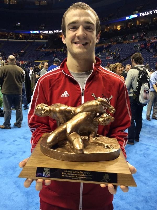 AJ Schopp holding a wrestling trophy in an arena