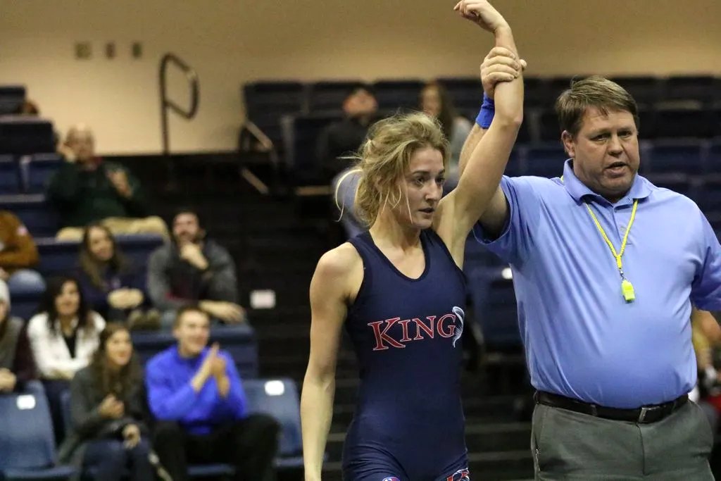 Ashley Iliff Gocklin in a King University singlet as the referee raises her arm after a win