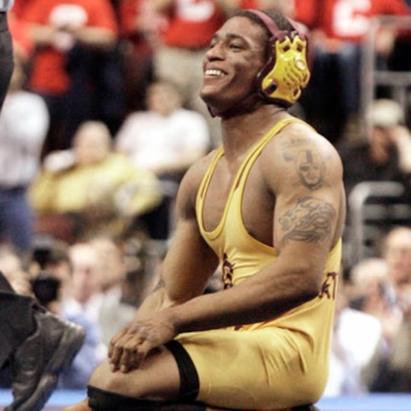 Anthony Robles kneeling on the mat and smiling, in an Arizona State singlet and headgear, Ken Chertow wrestling camp coach