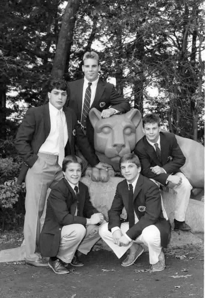 Black-and-white photo of five Penn State wrestlers in team blazers at the Nittany Lion Shrine