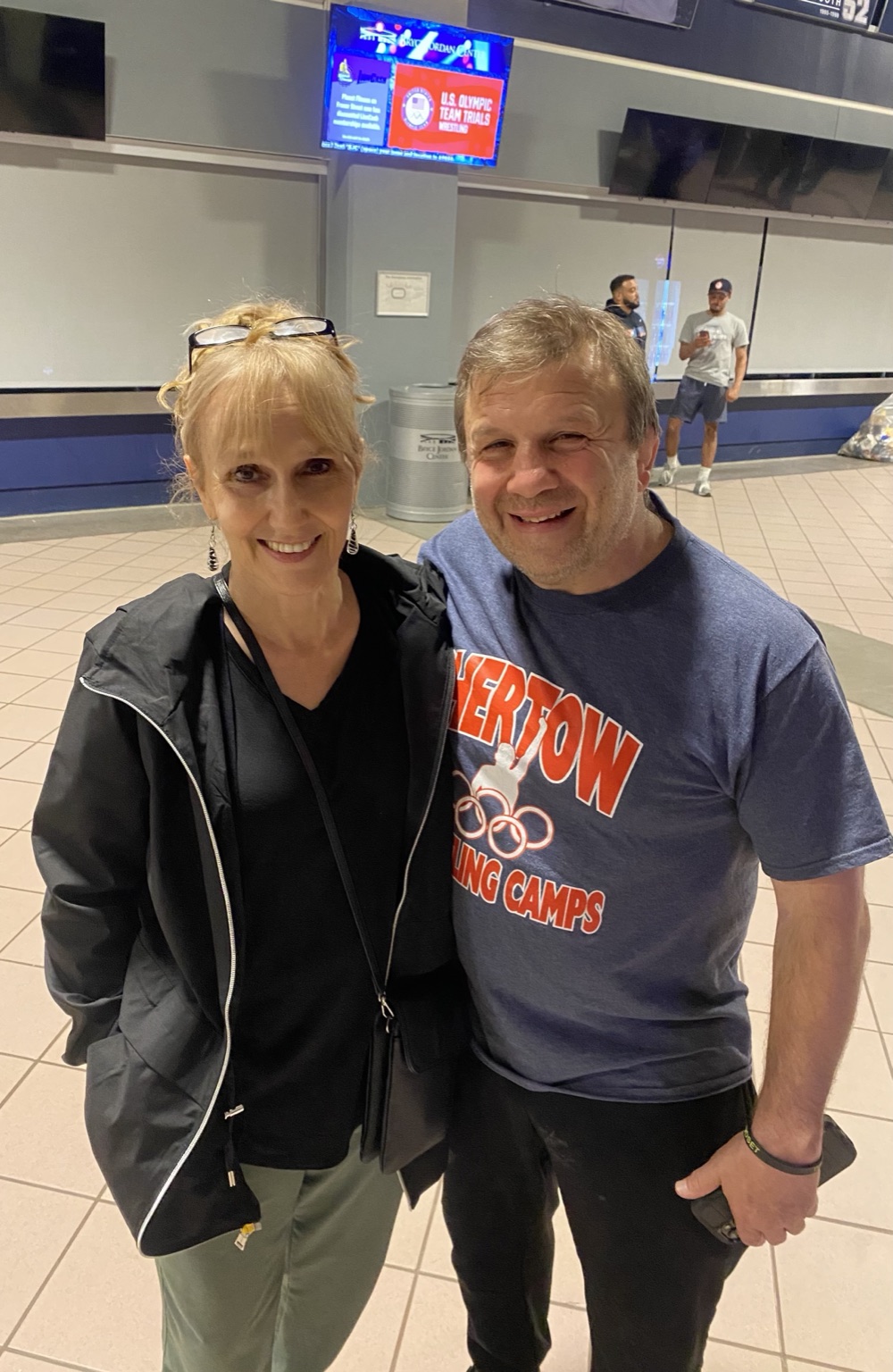 Tricia Saunders and Ken Chertow, in a Chertow camps T-shirt, smiling together at the U.S. Olympic Team Trials