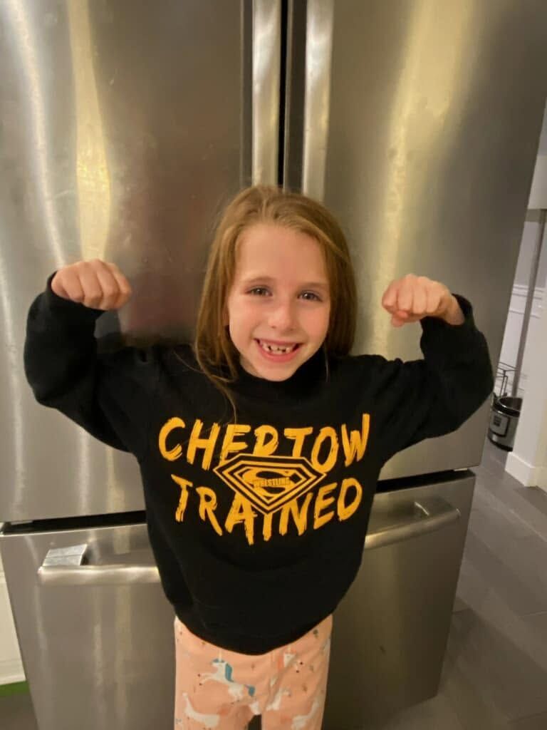 Zoe Morgan flexing both arms in a Chertow Trained sweatshirt
