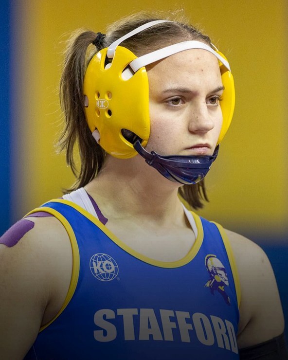 Abigail DeBerry in a blue singlet and yellow headgear
