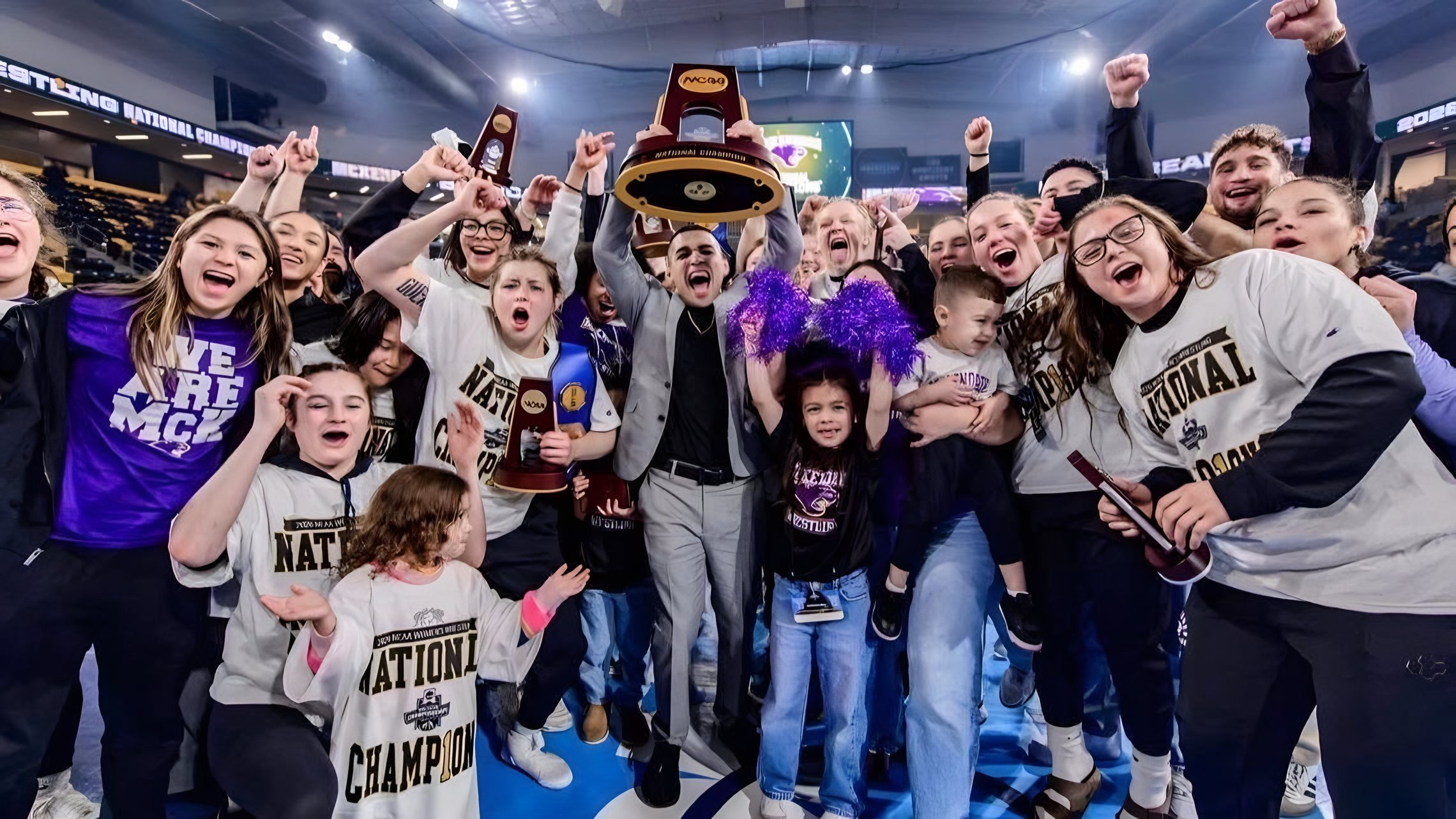 Ken Chertow wrestling camp coach Alexio Garcia and the McKendree women's team with their NCAA title trophy